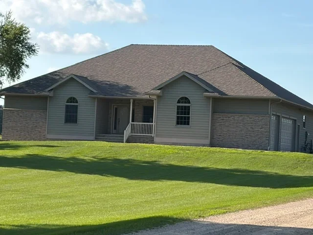 Charcoal gray asphalt shingle roof on residential home with brick and siding exterior